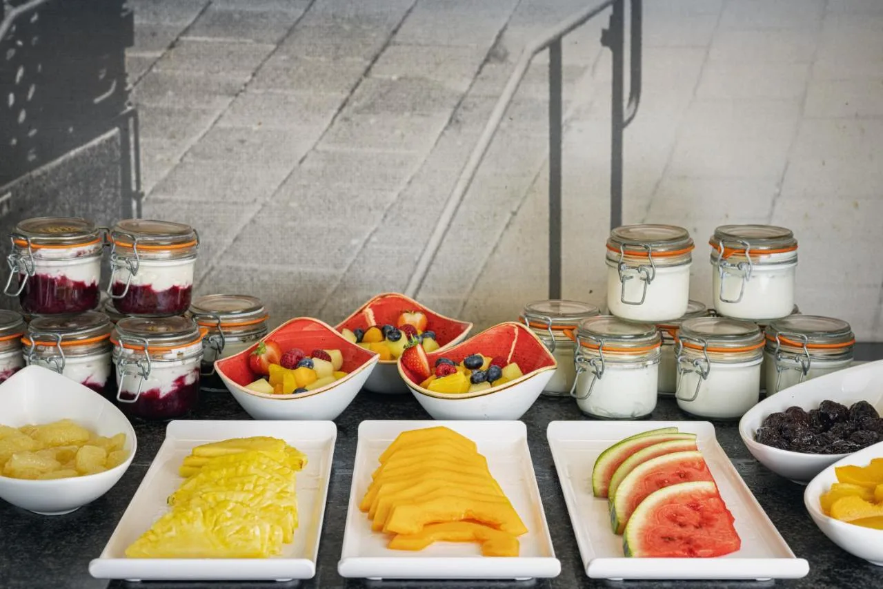 a table topped with plates of fruit and other foods at The Queens Gate Hotel in London